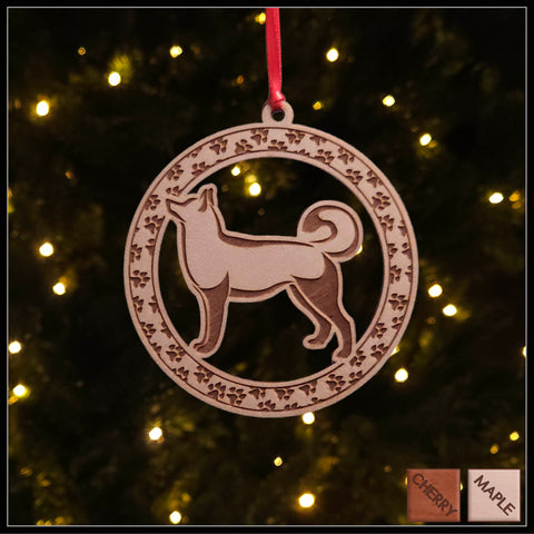 A round Maple wood veneer ornament with a border of small paw prints. The center of the ornament is a Husky dog.