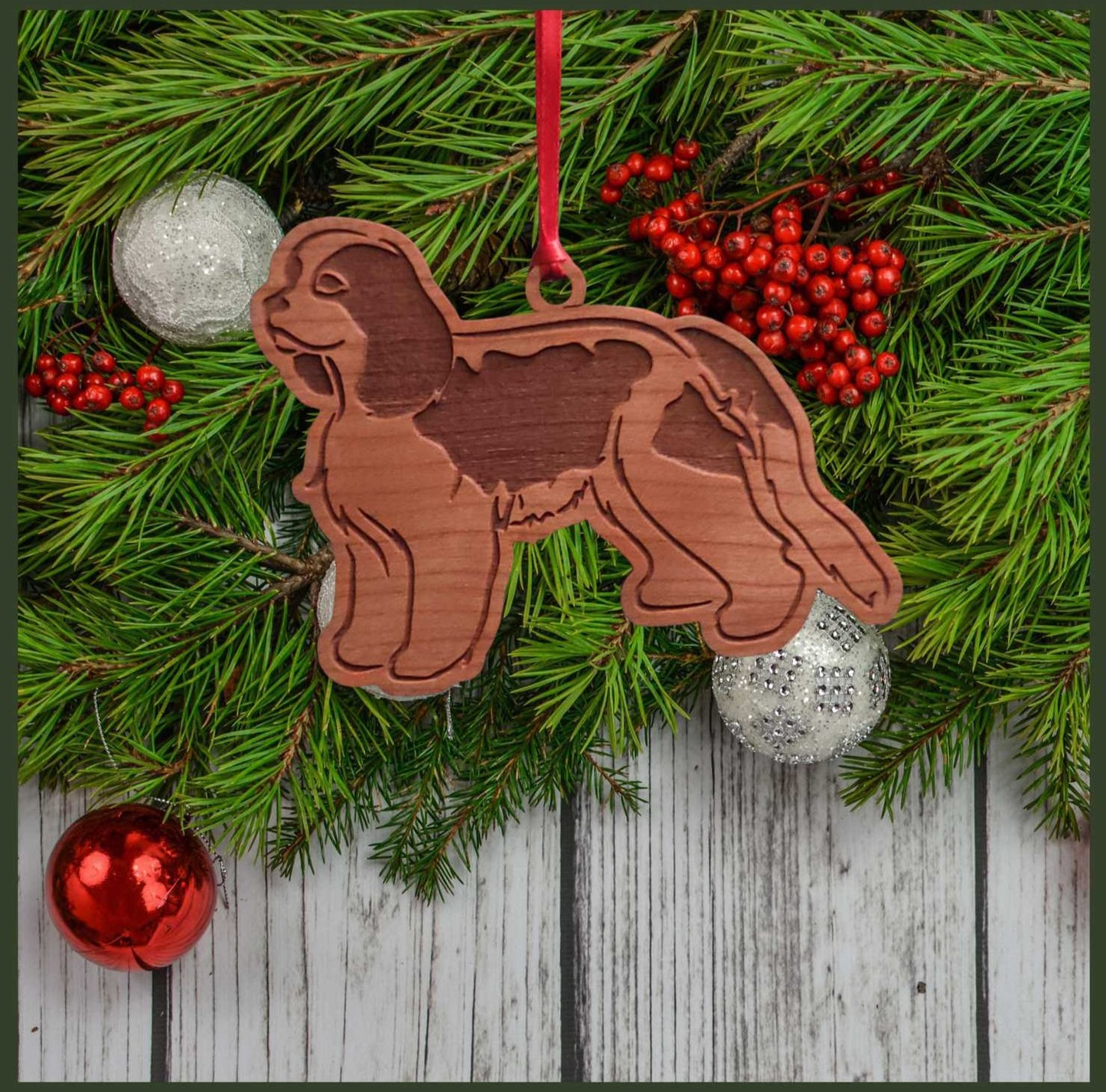 A Cavalier King Charles Spaniel cherry wood veneer ornament, with the dog in profile.