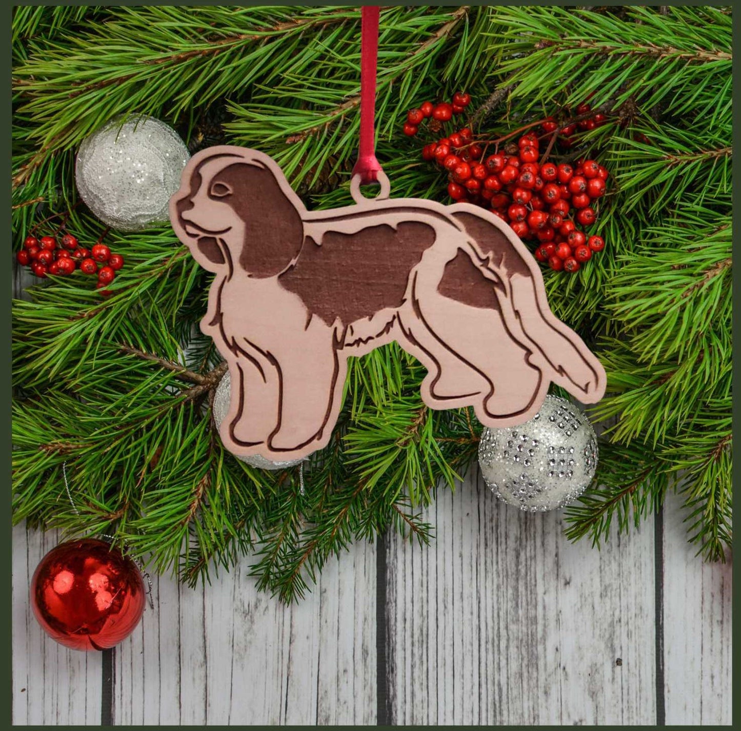 A Cavalier King Charles Spaniel maple wood veneer ornament, with the dog in profile.