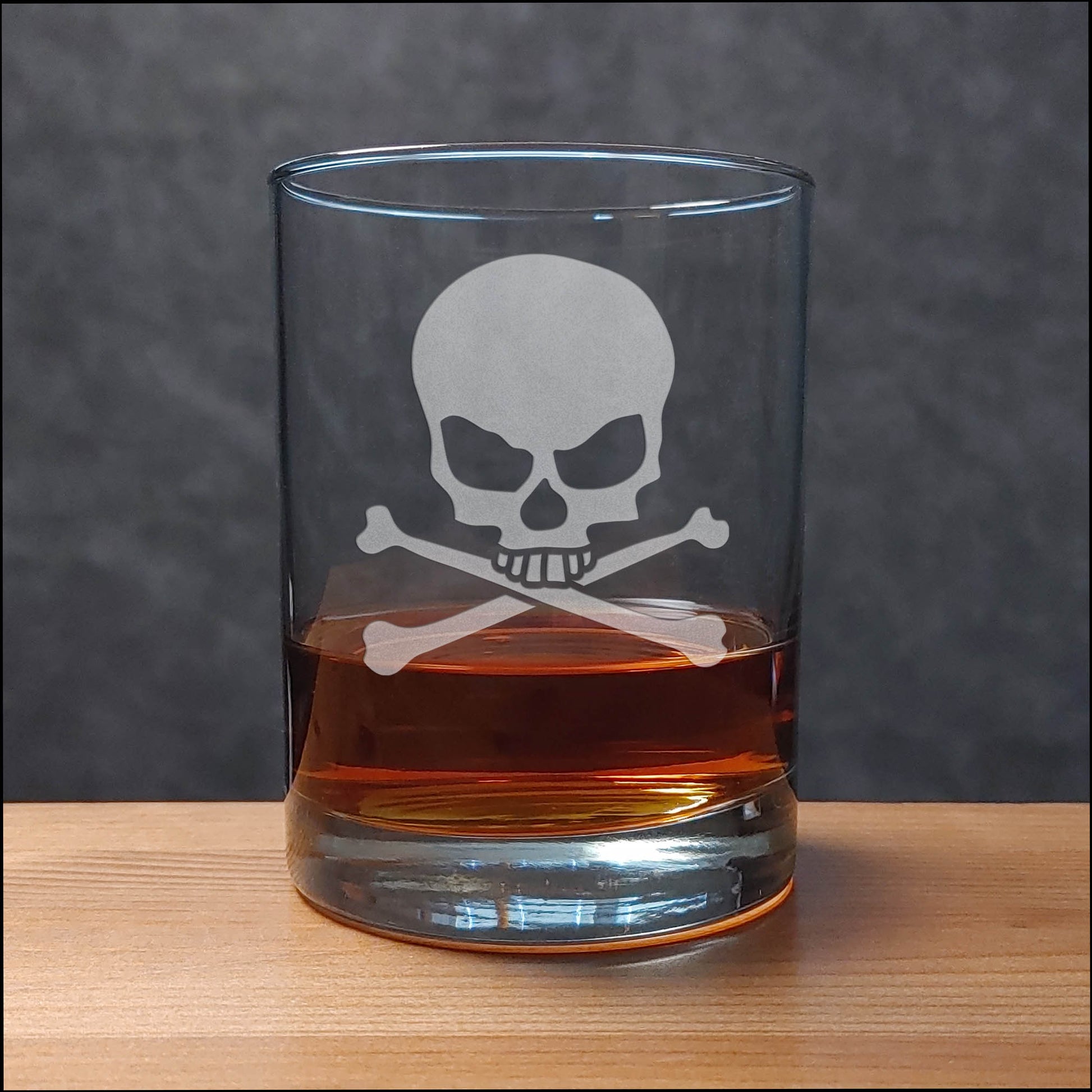 Glass with skull and crossbones design filled with a dark liquid on a wooden surface.