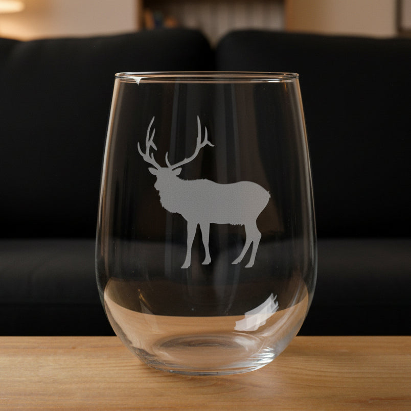 17oz Stemless Wine Glass with an etched image of a elk and a black couch in the background