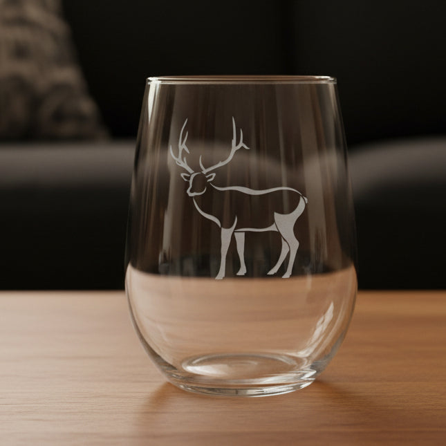 17oz Stemless Wine Glass with an etched image of a bear paw print and a black couch in the background