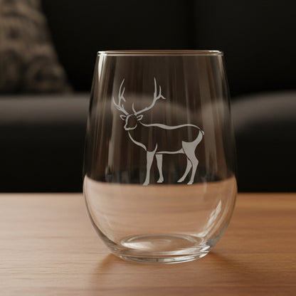 17oz Stemless Wine Glass with an etched image of a bear paw print and a black couch in the background