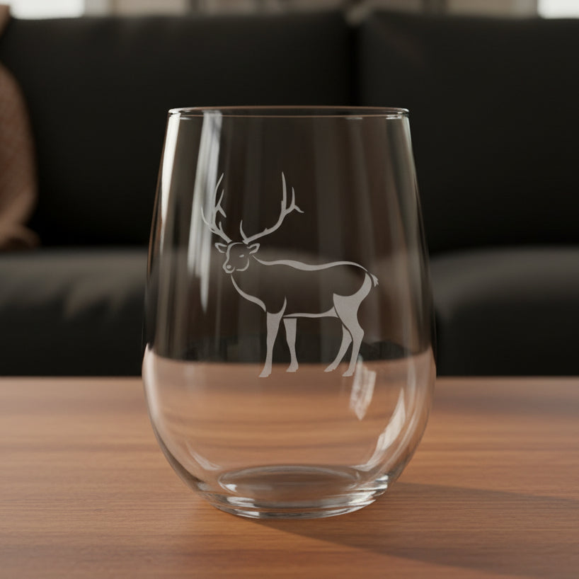 17oz Stemless Wine Glass with an etched image of a bear paw print and a black couch in the background