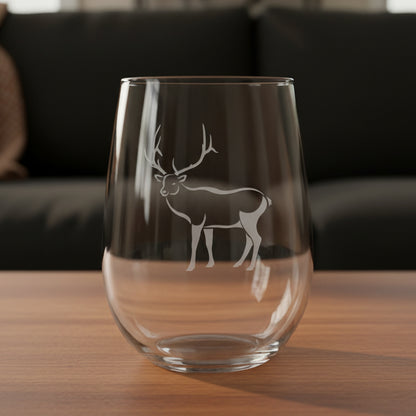 17oz Stemless Wine Glass with an etched image of a bear paw print and a black couch in the background