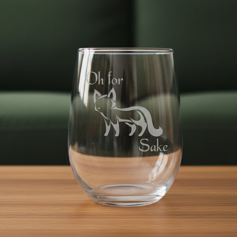 17oz Stemless Wine Glass with an etched image of a fox 
and a green couch in the background and the words "OH For" "Sake"  with a fox in the middle