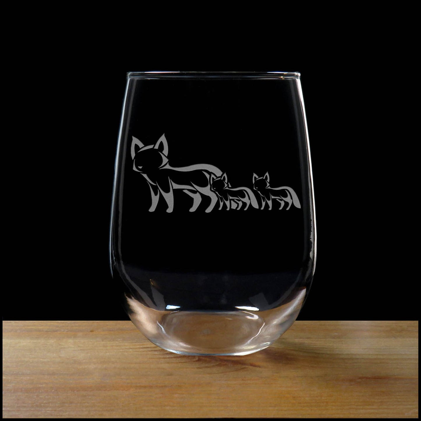17oz Stemless Wine Glass with an etched image of a fox, on a wood surface and a black background