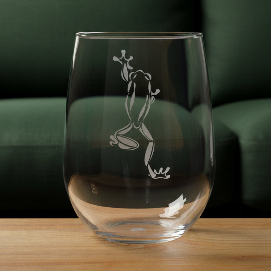 17oz Stemless Wine Glass with an etched image of a garden frog 
and a green couch in the background