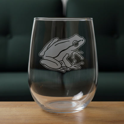 17oz Stemless Wine Glass with an etched image of a garden frog 
and a green couch in the background