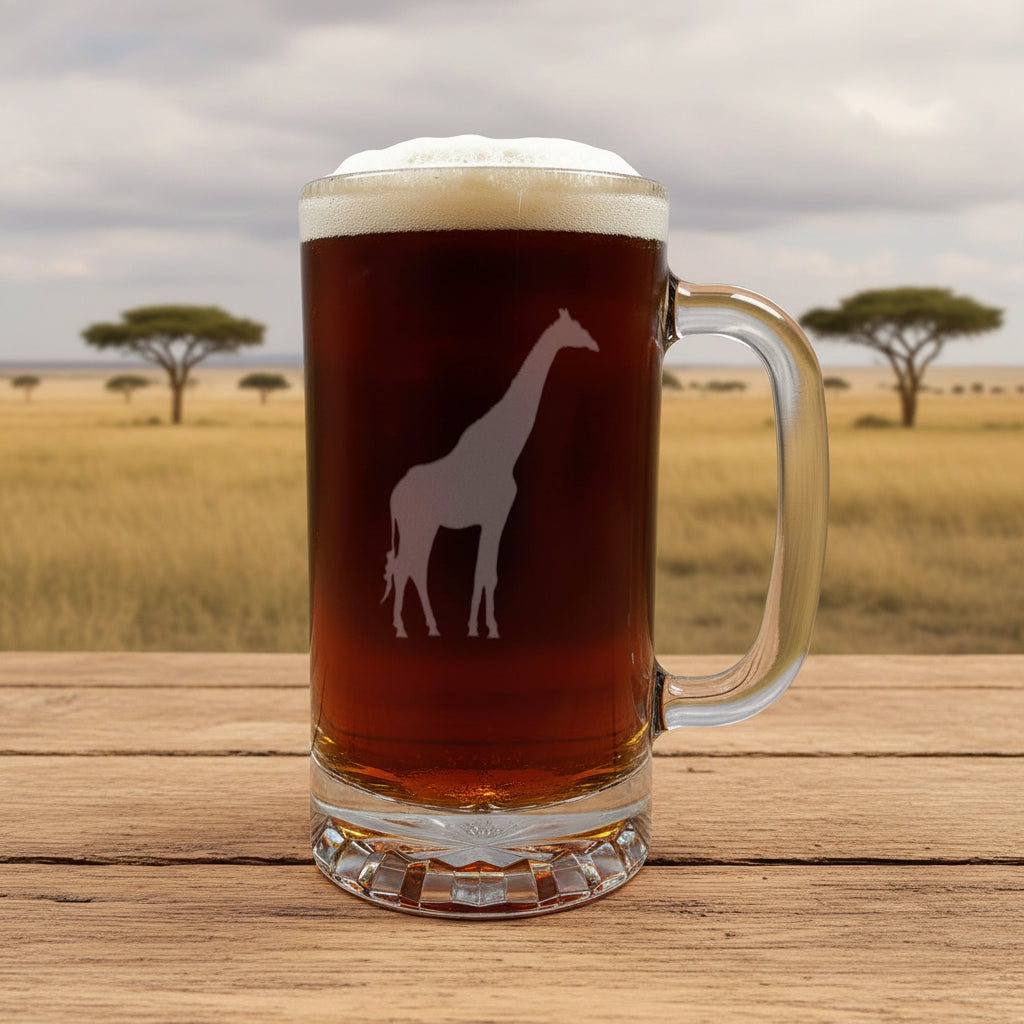 A clear glass beer mug with a handle, filled with dark beer and topped with white foam, featuring a white giraffe silhouette design on the front, set on a light wood surface against a savanna background.