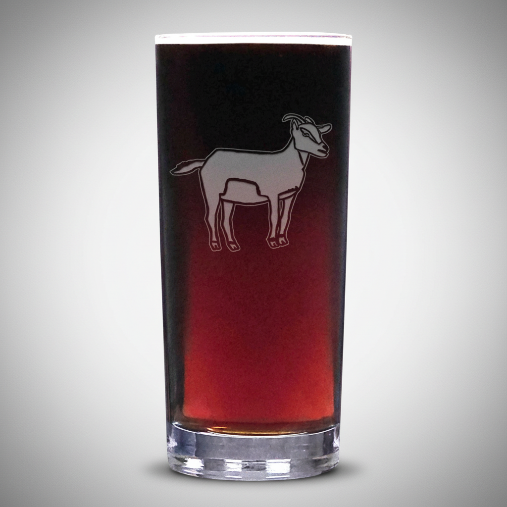 A clear glass shot glass featuring a white etched silhouette of a goat, shown filled with a dark red liquid against a plain light grey background.