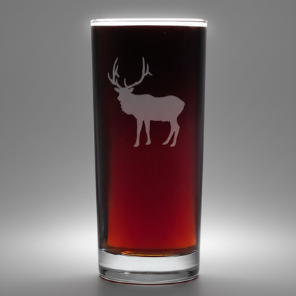 Glass with a deer etching on a grey background