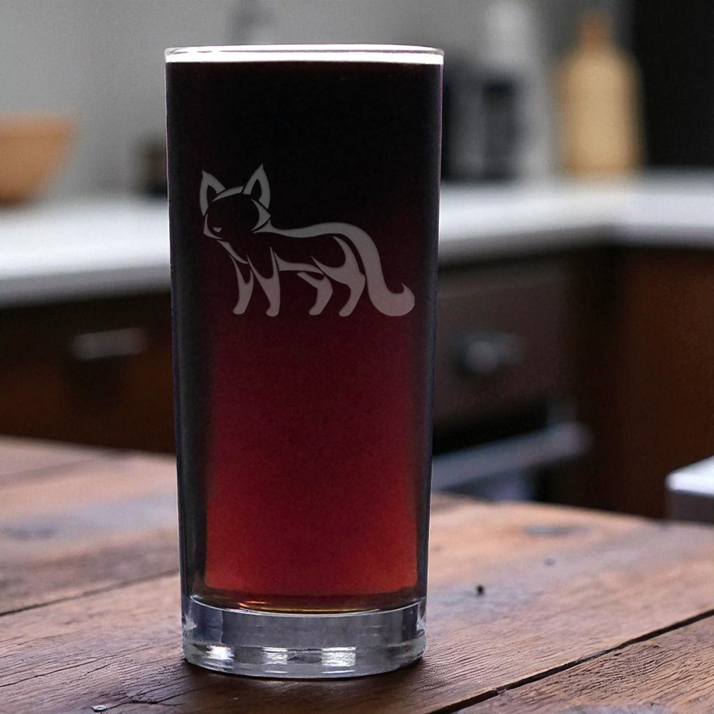 Glass with a cat design on a wooden surface in a kitchen setting