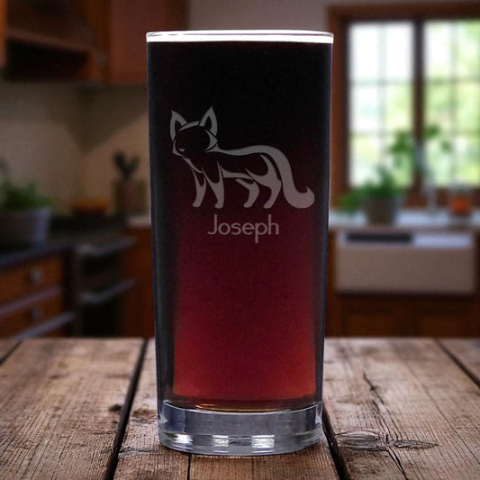 Clear glass with black base and red accent, featuring a fox design and 'Joseph' text, on a wooden surface.