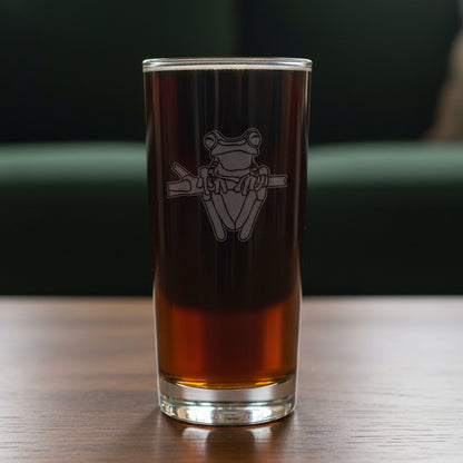 15oz Cooler Glass with an etched image of a garden frog 
and a green couch in the background