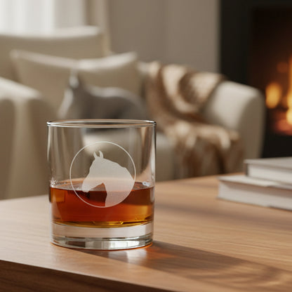 Glass with red amber liquid and horse head etched on iton a stone surface