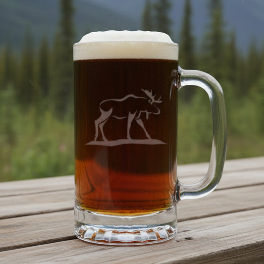 Glass mug with beer and a moose engraving on a wooden surface with a natural background