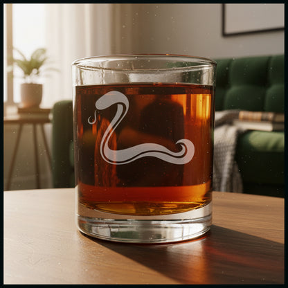Glass with red liquid and a etched snake design i a cozy livingroom