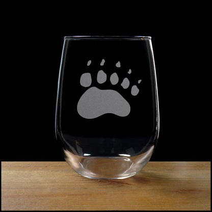 17oz Stemless Wine Glass with an etched image of a bear paw print, on a wood surface and a black background