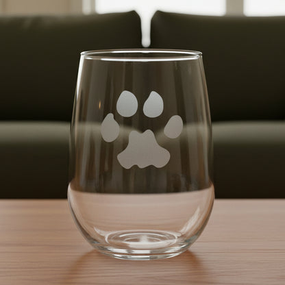 17oz Stemless Wine Glass with an etched image of a cougar paw print and a green couch in the background