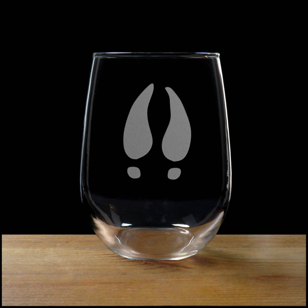 17oz Stemless Wine Glass with an etched image of a Deer Track, on a wood surface with a black background