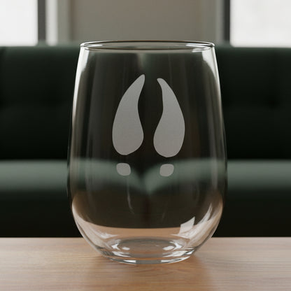17oz Stemless Wine Glass with an etched image of a deer track with a black couch in the background
