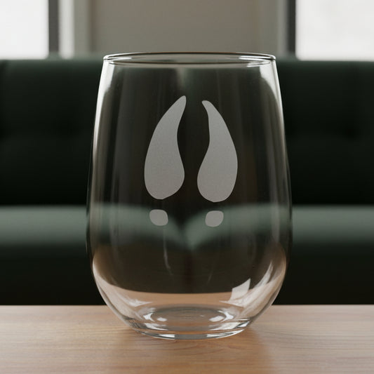 17oz Stemless Wine Glass with an etched image of a deer track with a black couch in the background