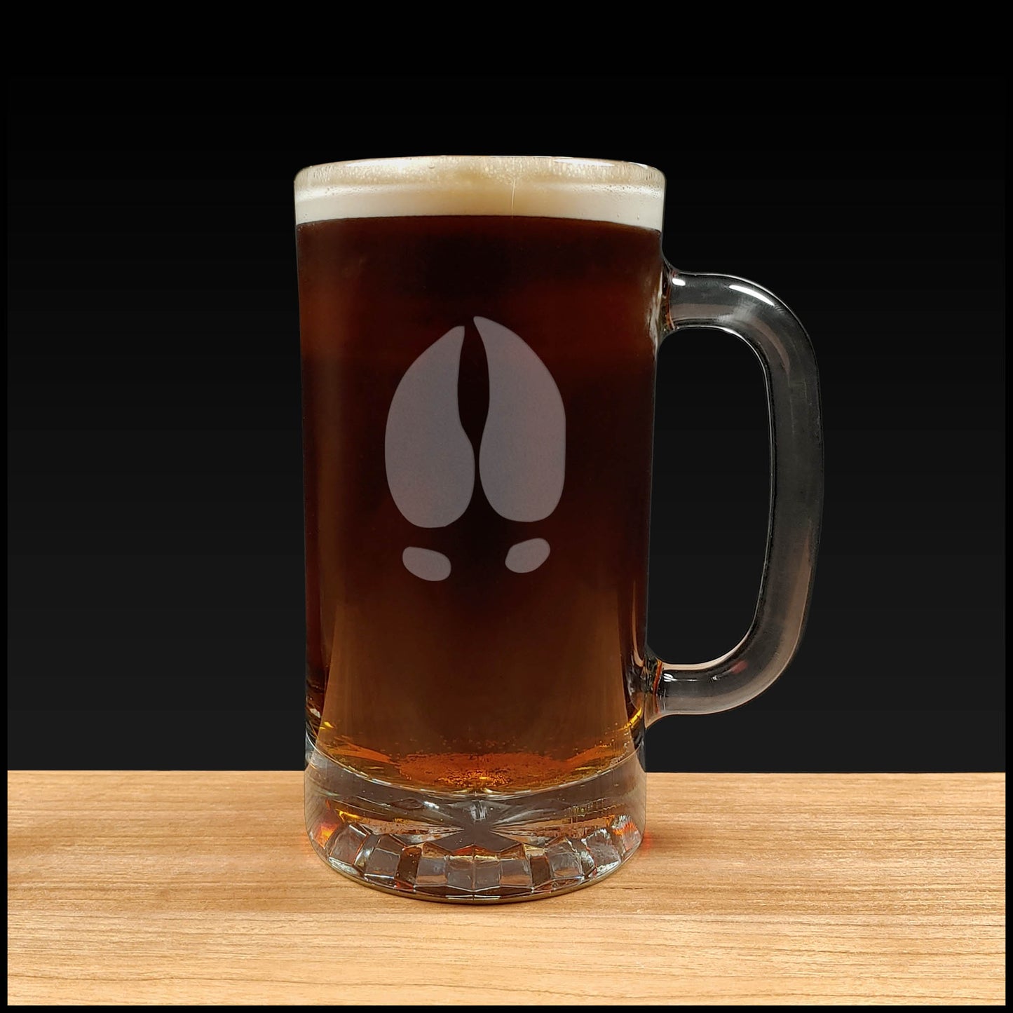 16oz Beer Mug with an etched image of a bear track a black background