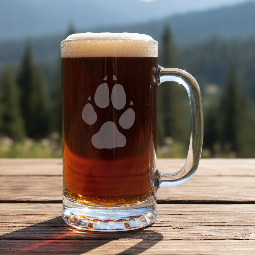 Etched Wolf Track 16oz beer mug with a forest in the background