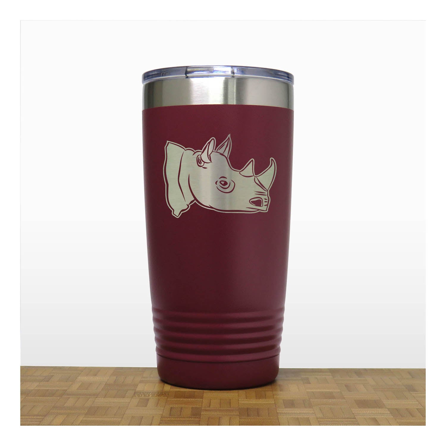 Maroon tumbler with rhino design on a white background