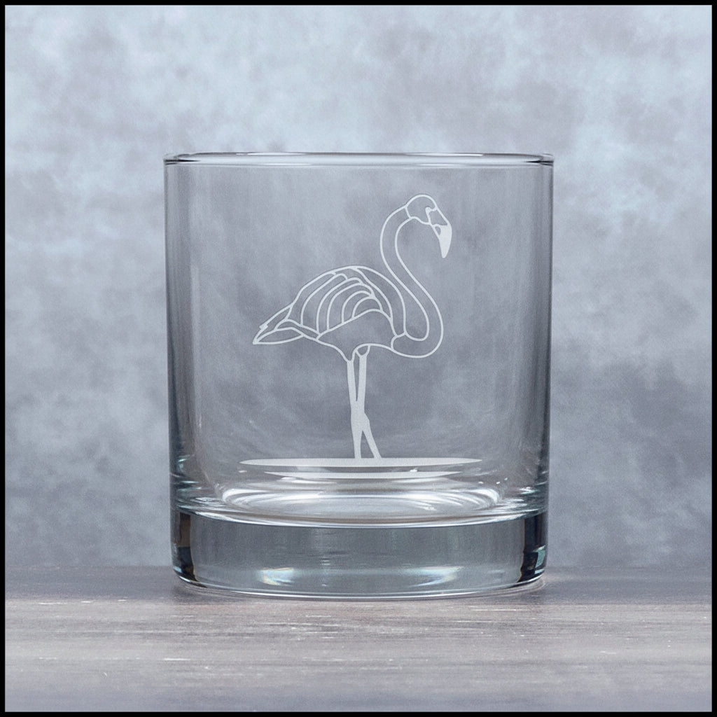 Glass with a flamingo design filled with red liquid on a gray background