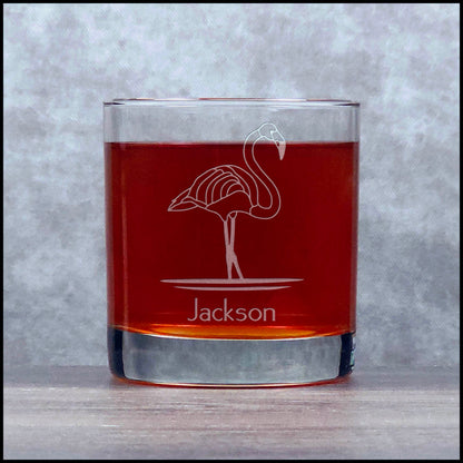 Glass tumbler with flamingo design and 'Jackson' engraving on a gray background