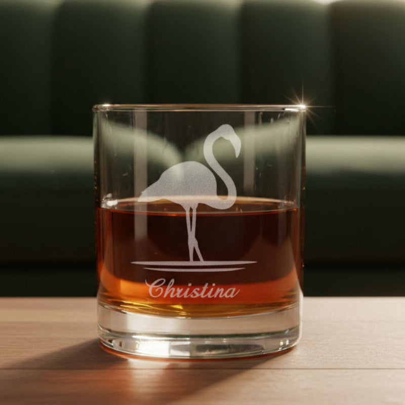 Glass with flamingo design and 'Christina' engraving with a green couch in the background