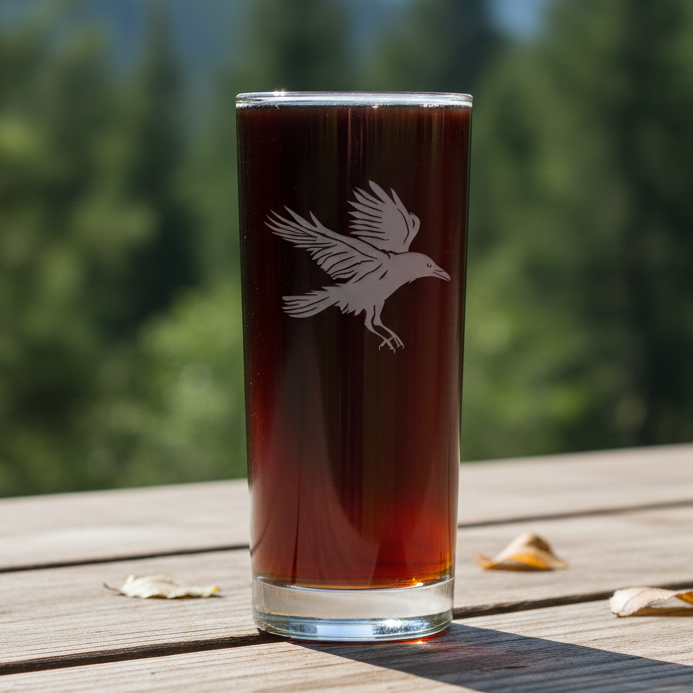 Glass with a Raven design with a blurred forest in the  background