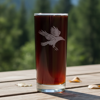 Glass with a Raven design with a blurred forest in the  background