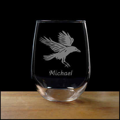 Clear glass with engraved bird design and name 'Michael' on a wooden surface with black background