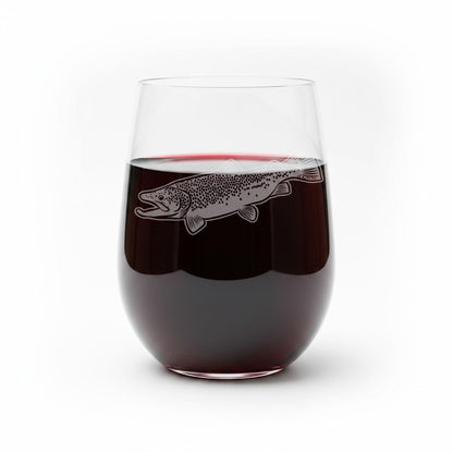 A clear stemless wine glass filled with red wine, featuring an etched fish design on the front, set against a plain white background.