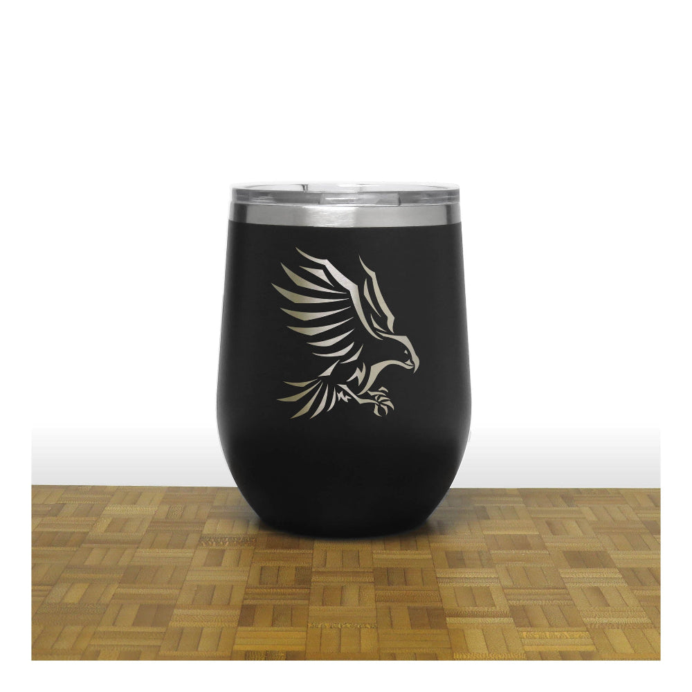 Black tumbler with an eagle design on a wooden surface