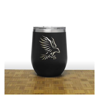 Black tumbler with an eagle design on a wooden surface