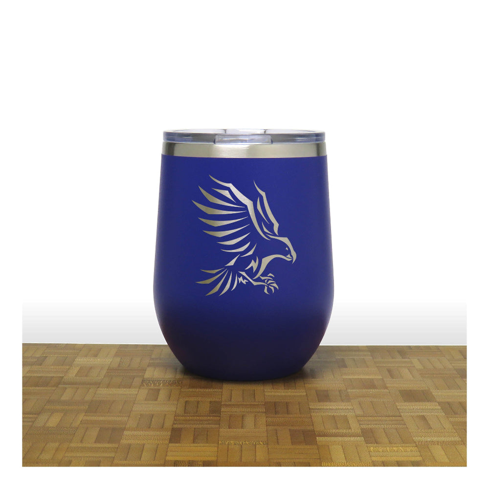 Blue insulated tumbler with an eagle design on a wooden surface
