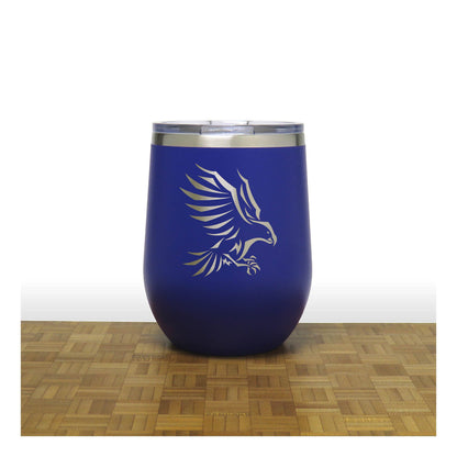Blue insulated tumbler with an eagle design on a wooden surface