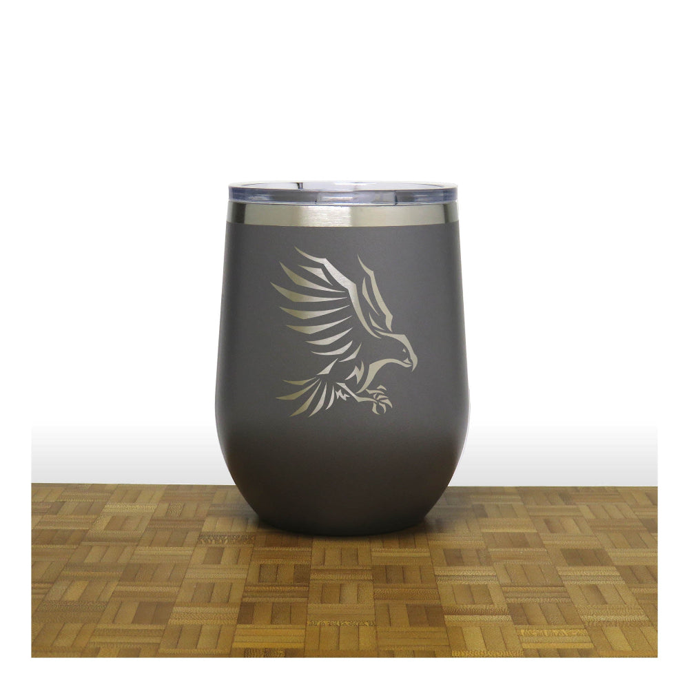 Dark gray tumbler with an eagle design on a wooden surface and white background