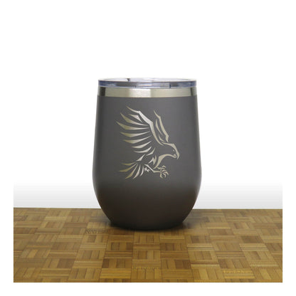 Dark gray tumbler with an eagle design on a wooden surface and white background