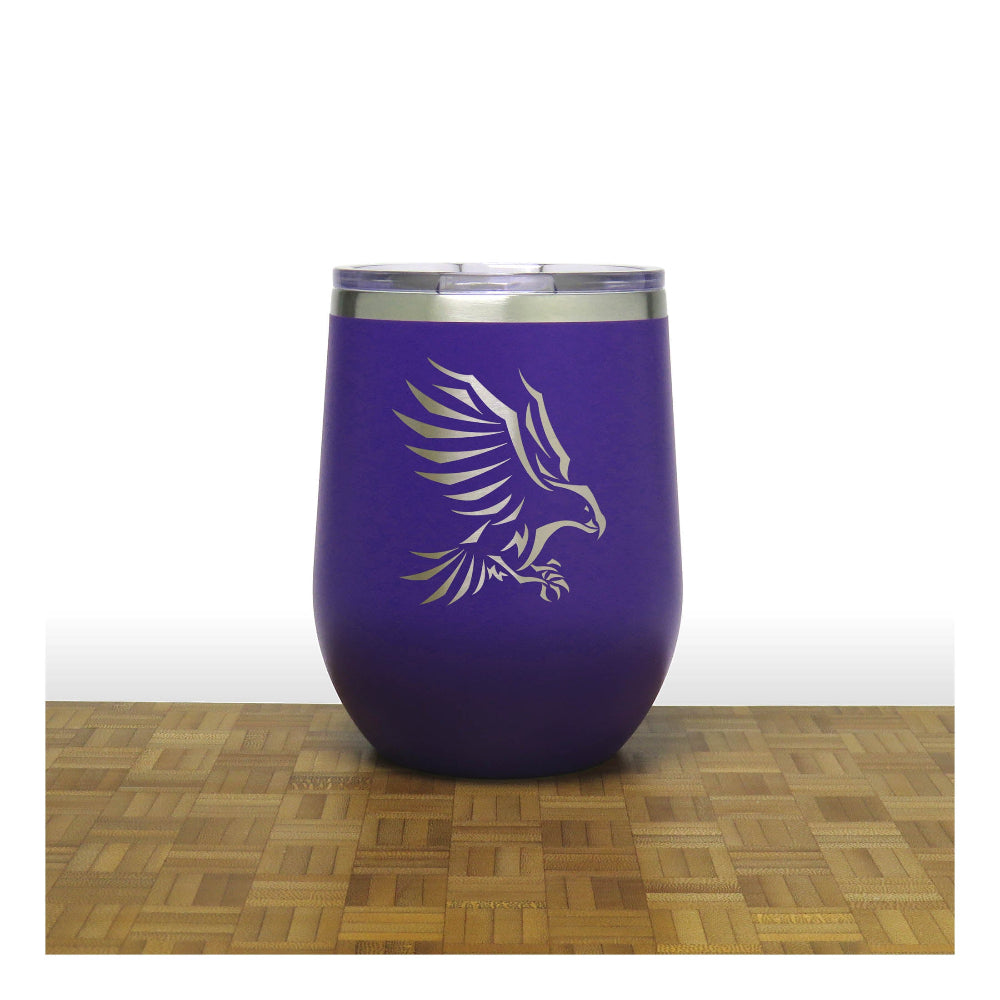 Purple tumbler with an eagle design on a wooden surface and white background