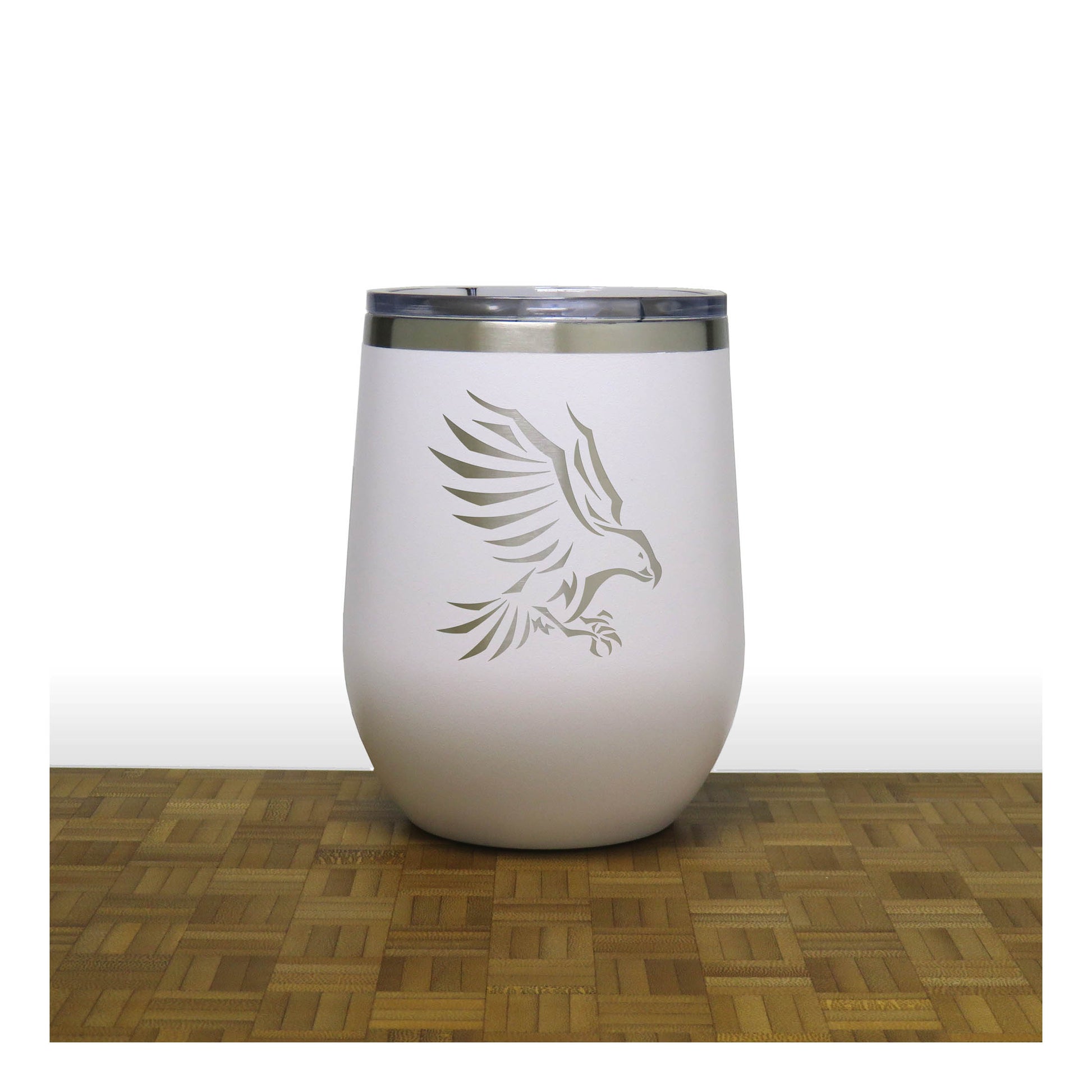 White tumbler with an eagle design on a wooden surface