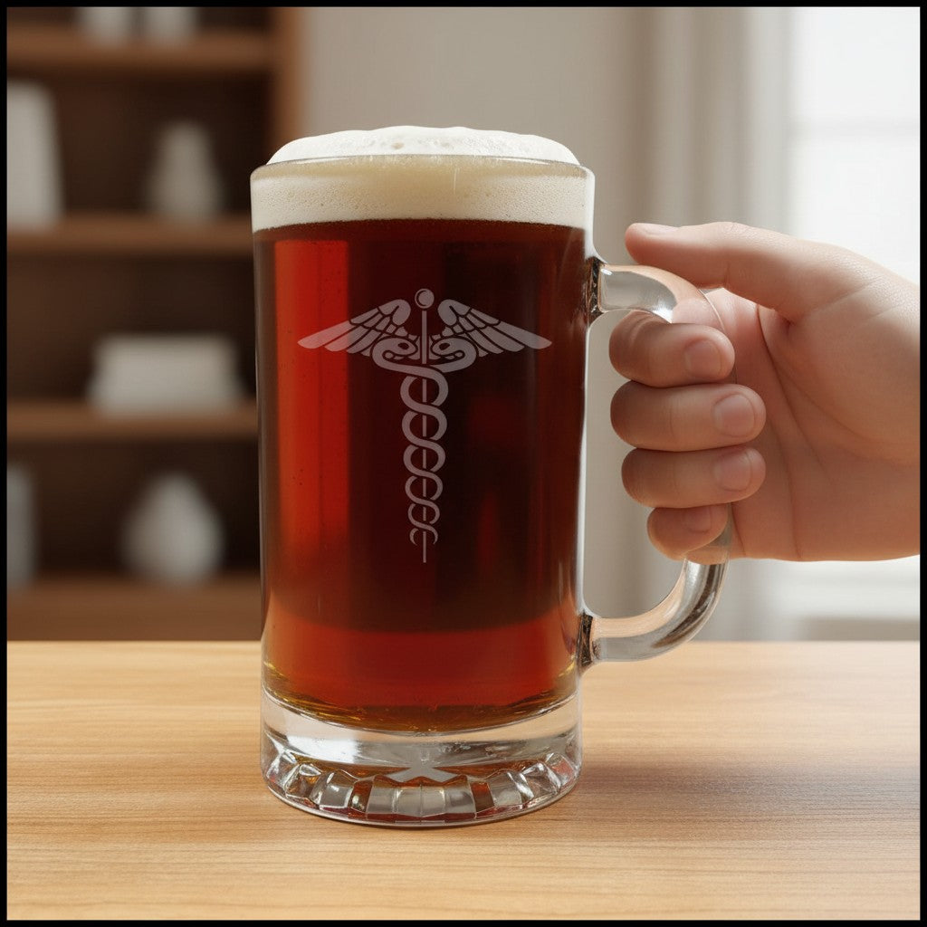 A frosted glass beer mug filled with amber beer and topped with white foam, held by a hand on a wooden table. The mug features an etched medical caduceus symbol on the front.