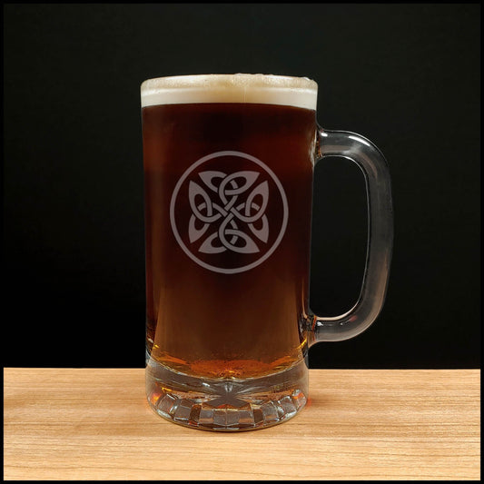 Glass mug of dark beer with a Celtic knot design on a wooden surface and black background
