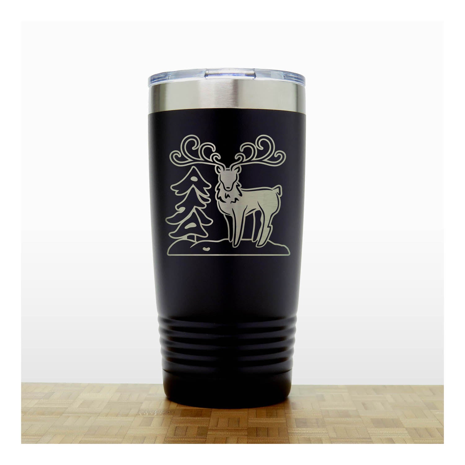Black - Insulated Travel Mug with the design of a Reindeer sta nding beside a Christmas tree - Copyright Hues in Glass