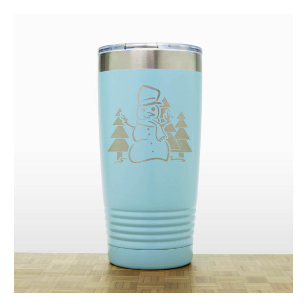 Teal 20 oz Insulated Tumbler with the design of a snowman standing in front of Christmas trees - Copyright Hues in Glass