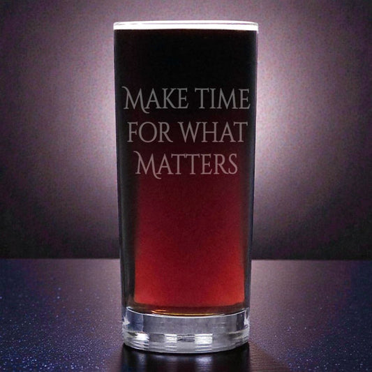 Glass with red liquid and motivational text, “Make Time for Those Who Matter” on a dark background